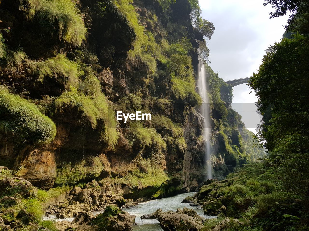 Scenic view of waterfall against sky