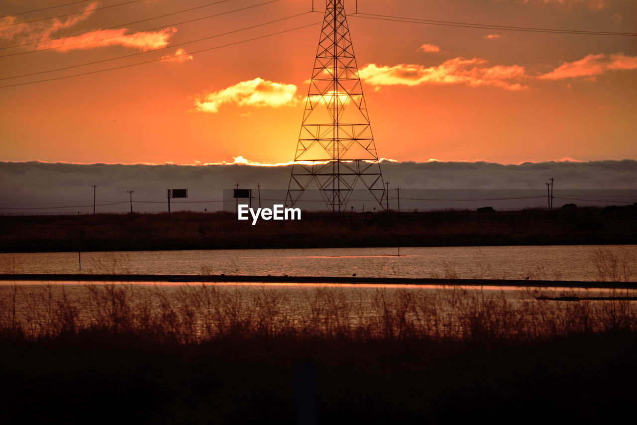 ELECTRICITY PYLONS AGAINST ORANGE SKY