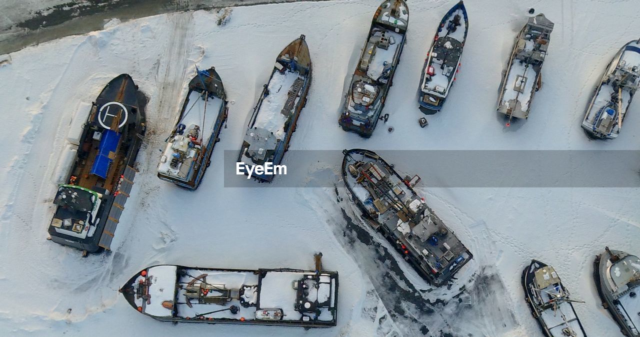 HIGH ANGLE VIEW OF BOATS IN SNOW COVERED LANDSCAPE
