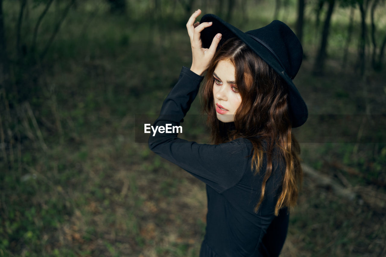 portrait of young woman wearing hat standing outdoors