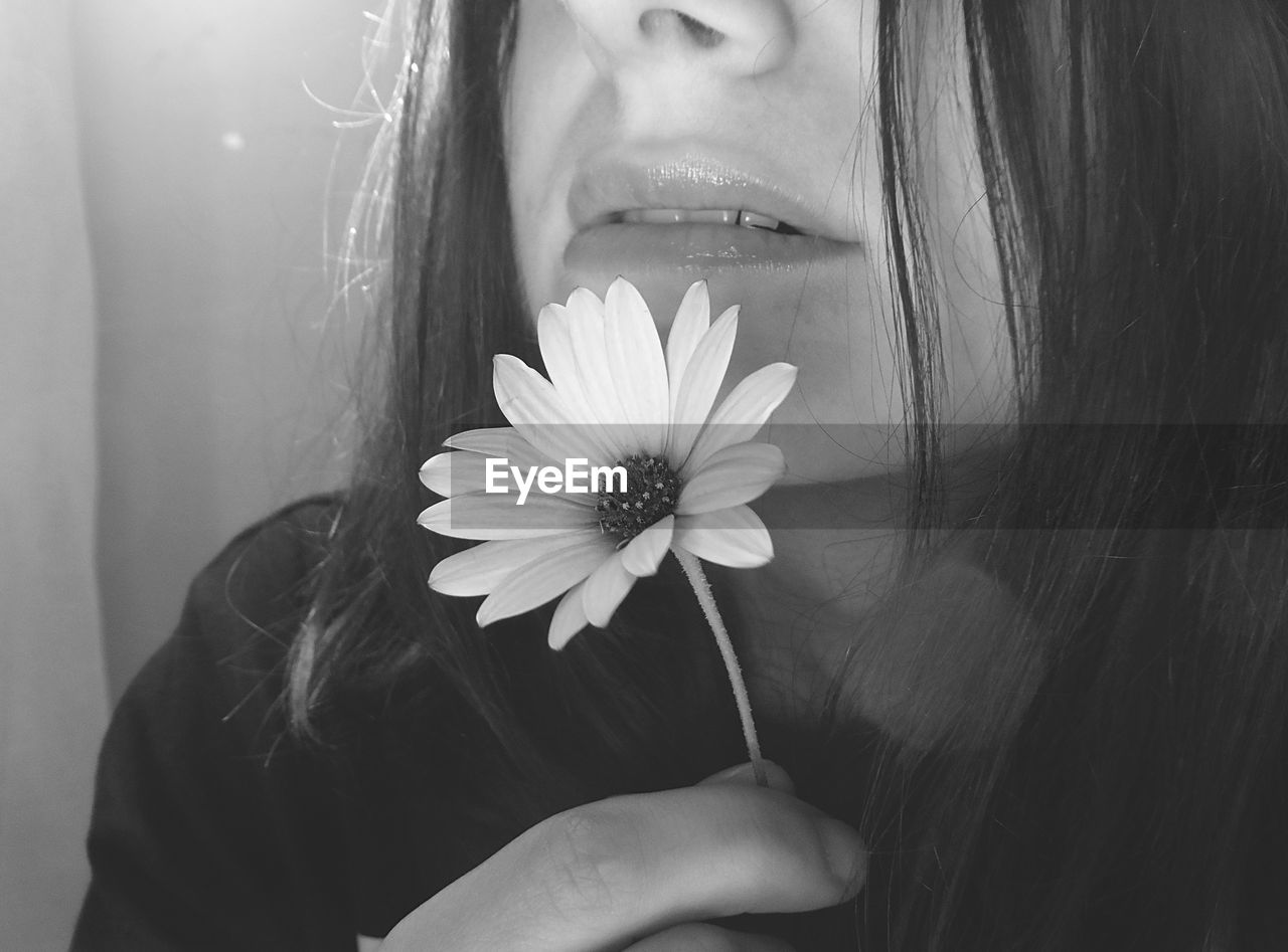 Cropped image of woman holding flower