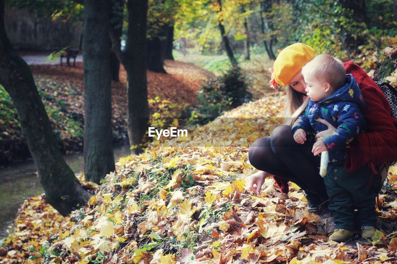 Mother and son in colorful forest during autumn