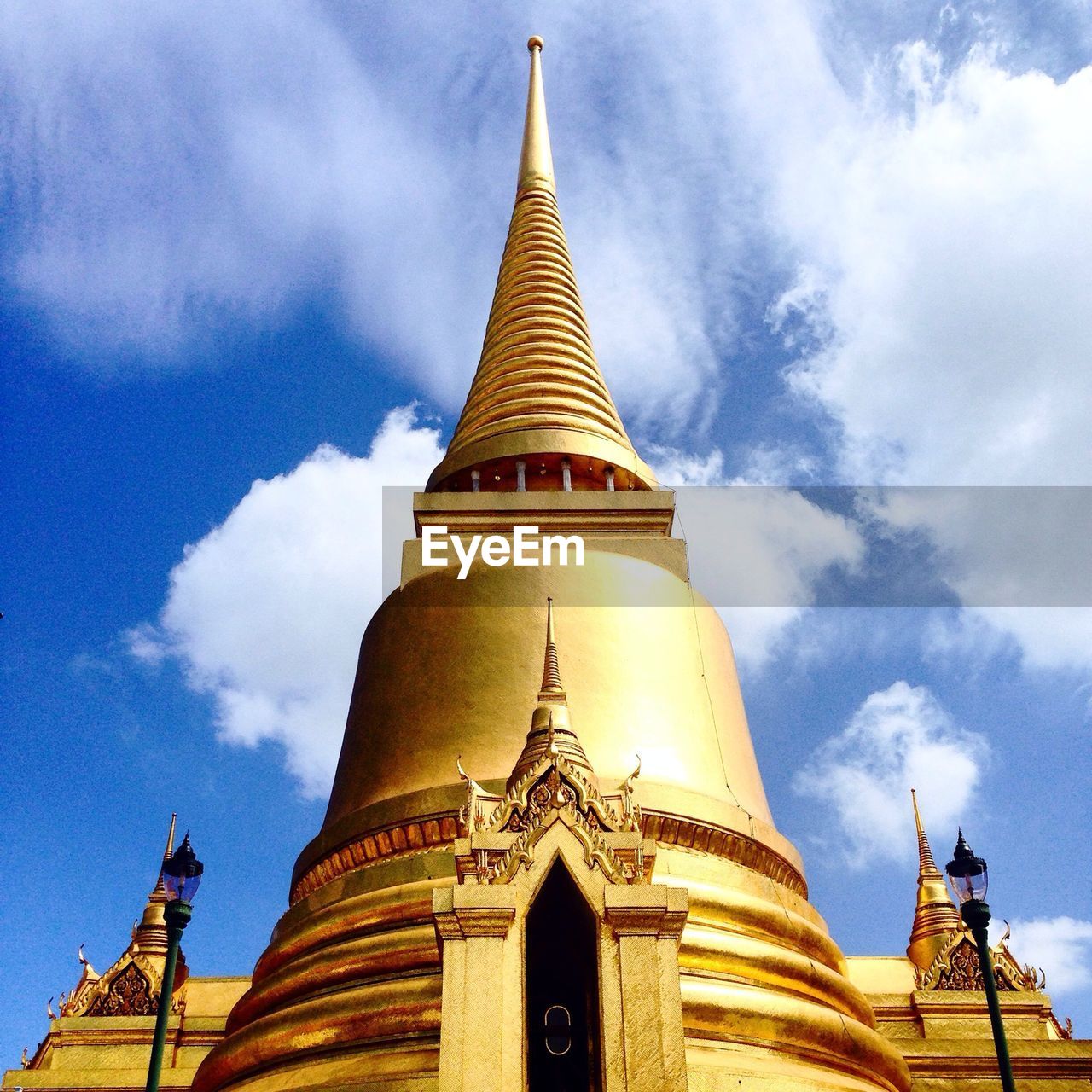 Low angle view of wat phra kaew against cloudy sky