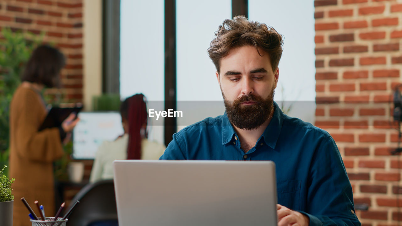 young man using digital tablet while sitting at home