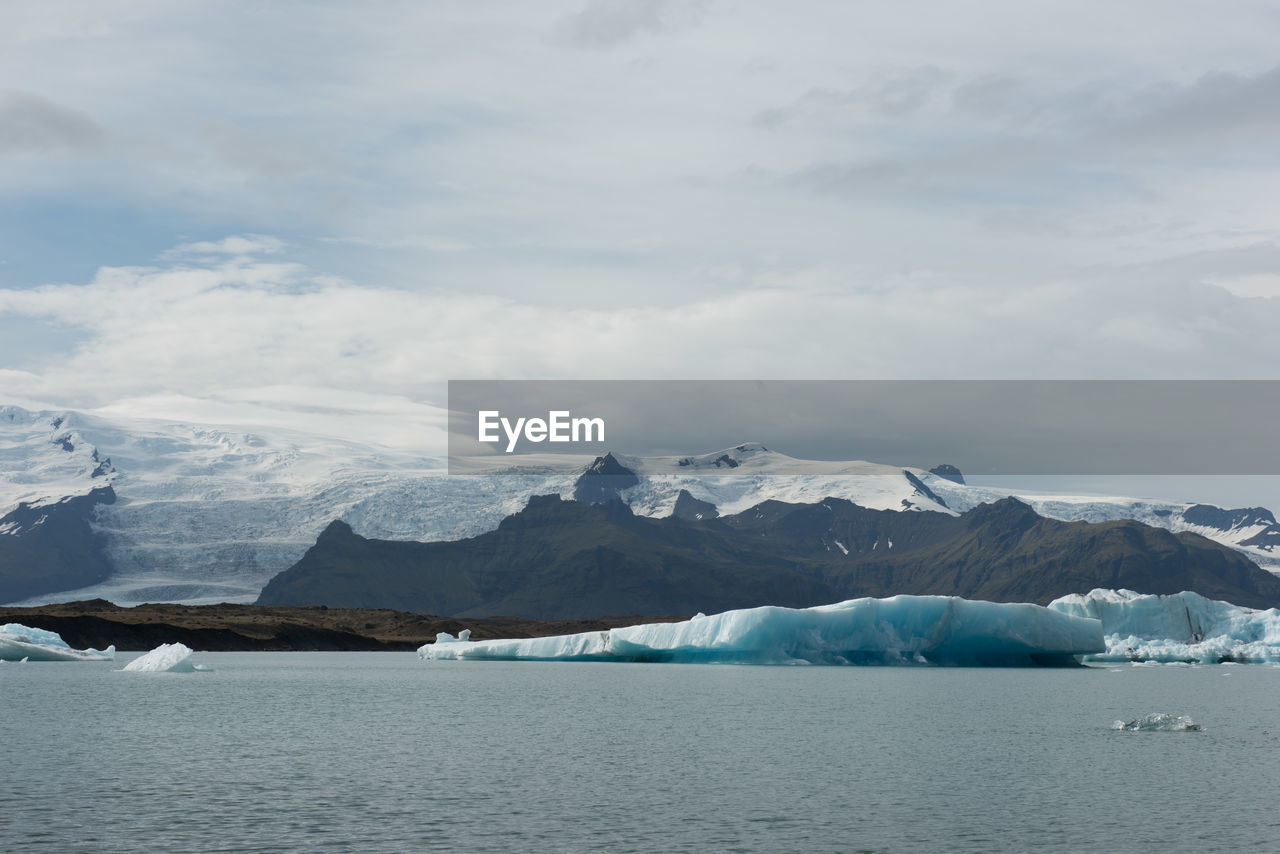 SCENIC VIEW OF FROZEN LAKE AGAINST MOUNTAIN