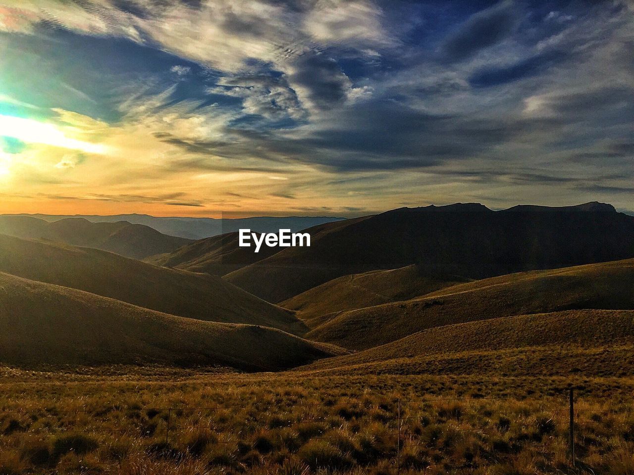 Scenic view of landscape against cloudy sky