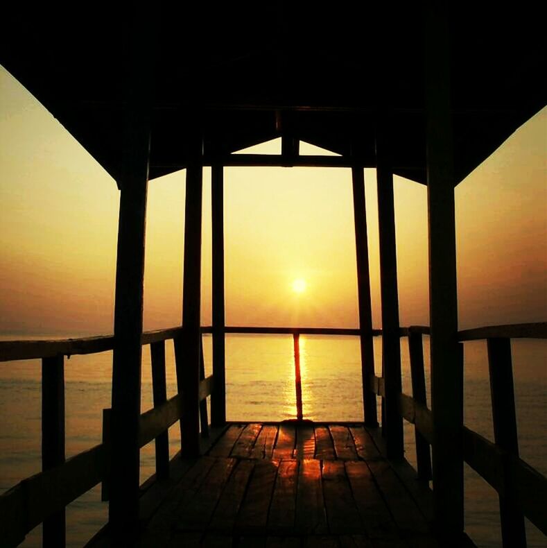 Silhouette gazebo against sea and clear sky during sunset