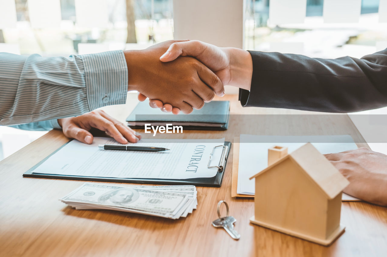 cropped hand of business colleagues shaking hands in office