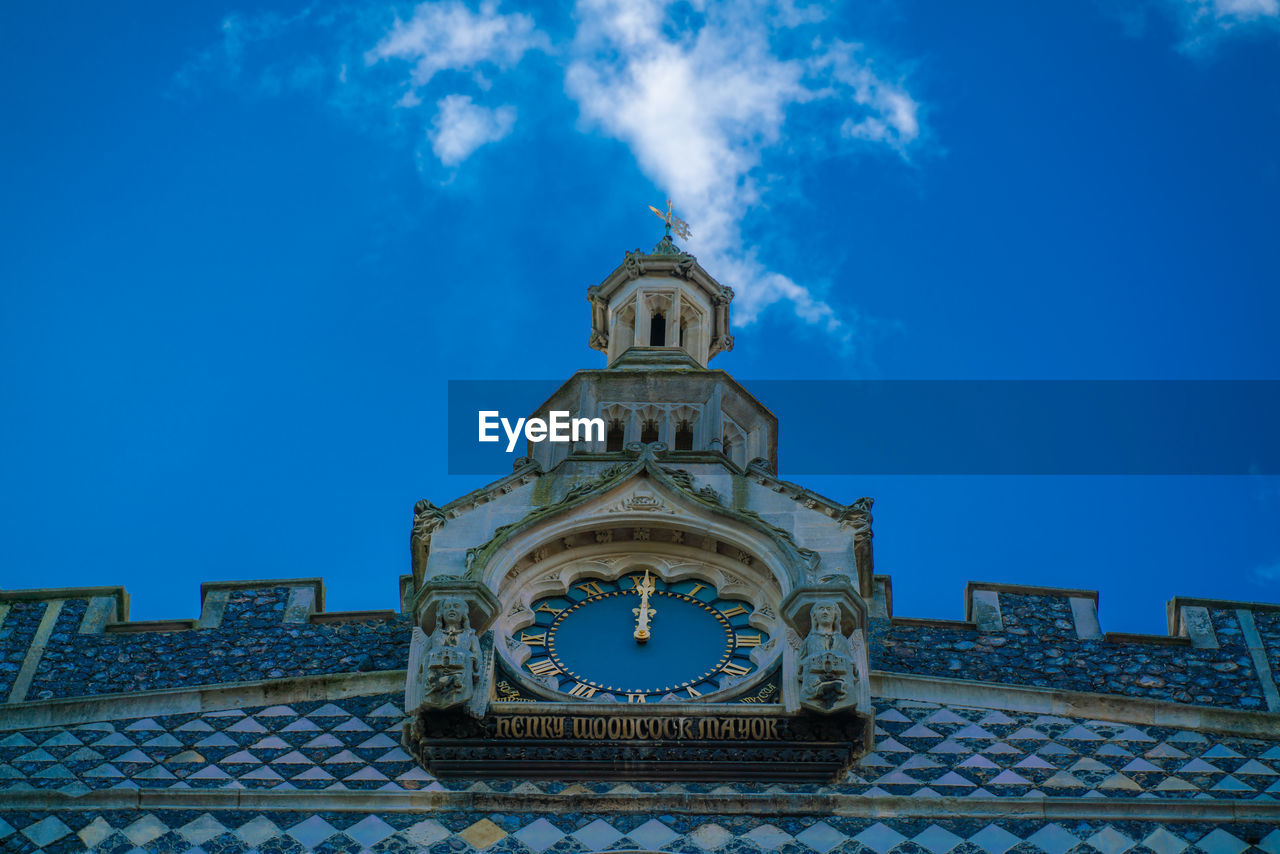 Low angle view of clock tower against blue sky