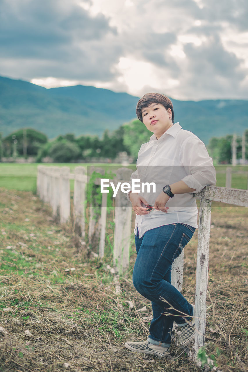 Portrait of young woman standing at farm