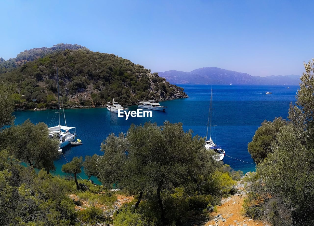 Scenic view of bay against clear blue sky