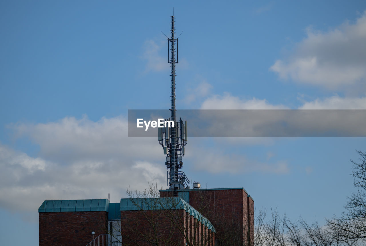 sky, architecture, built structure, blue, cloud, tower, technology, building exterior, nature, no people, low angle view, communications tower, antenna, day, communication, broadcasting, industry, wind, building, satellite dish, outdoors, spire, skyscraper, satellite, telecommunications equipment, outdoor structure, metal, mast, tree