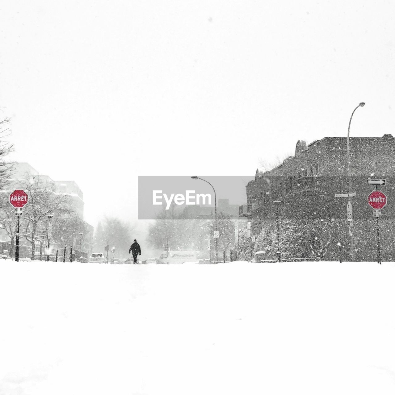 MAN WALKING ON SNOW COVERED LANDSCAPE