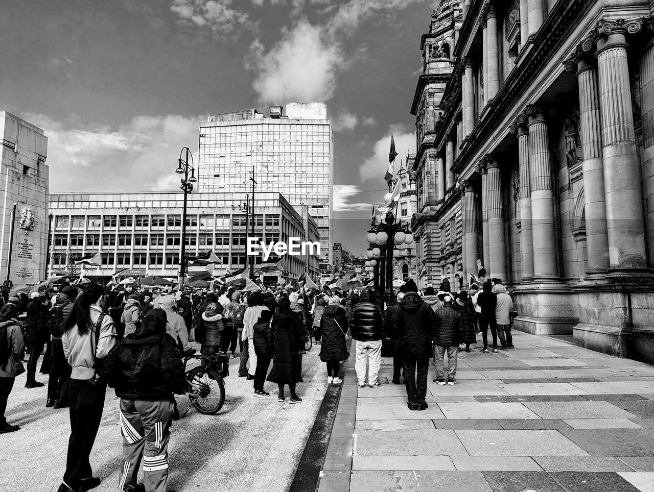 architecture, street, road, city, building exterior, built structure, black and white, urban area, group of people, crowd, infrastructure, monochrome, large group of people, monochrome photography, city life, sky, walking, adult, men, women, city street, building, cityscape, metropolis, lifestyles, day, nature, travel destinations, outdoors, person, transportation, cloud, black, travel, downtown