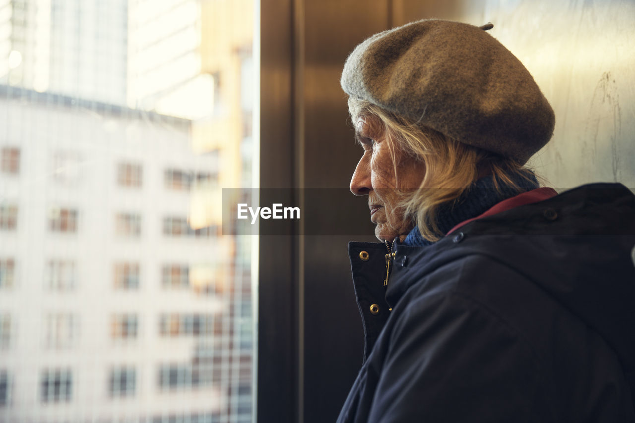 Senior woman looking through window