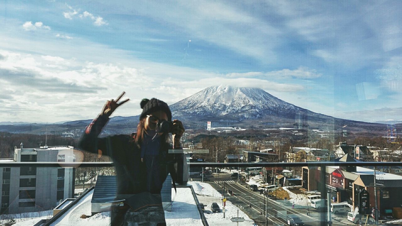 Woman taking self photograph with mt fuji in mirror reflection