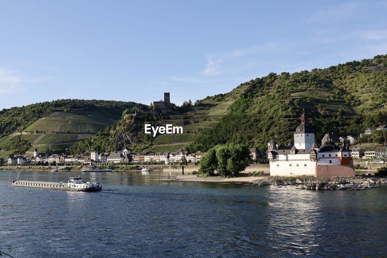 SCENIC VIEW OF RIVER BY TREES AND BUILDINGS AGAINST SKY