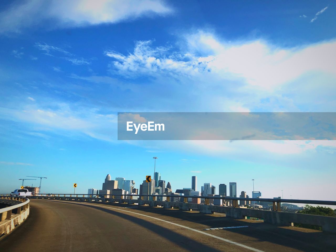 ROAD BY BUILDINGS IN CITY AGAINST SKY