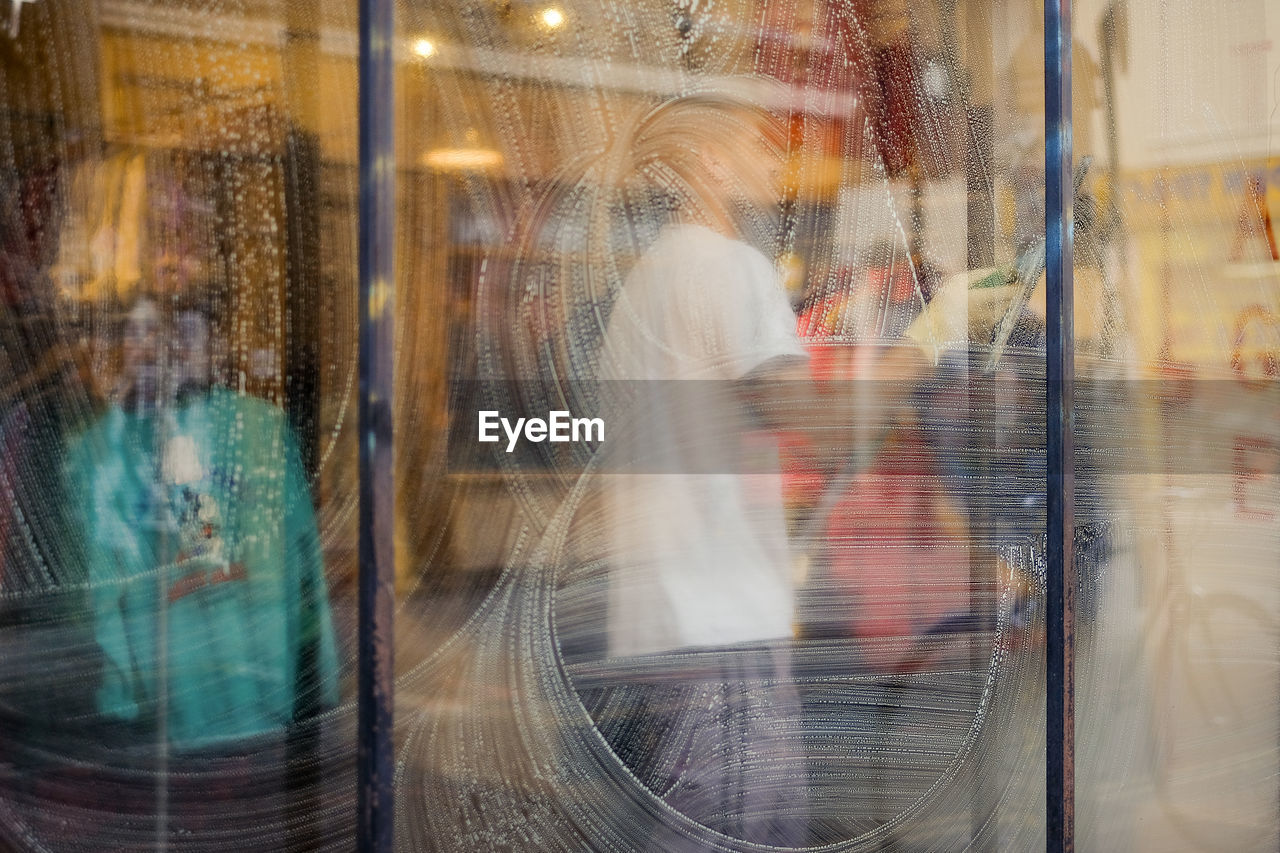 Man cleaning window in clothing store