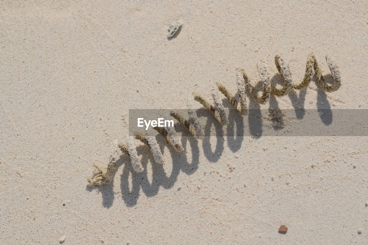 HIGH ANGLE VIEW OF TEXT ON BEACH