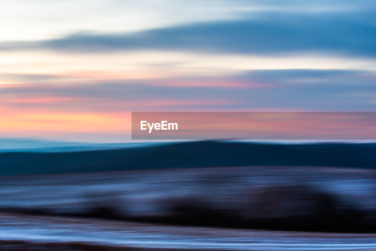 Scenic view against dramatic sky during sunset