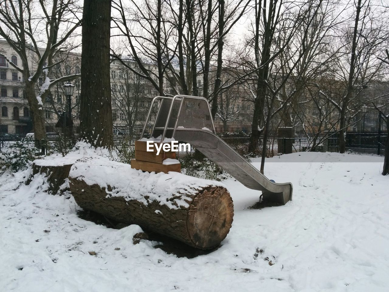 Log and slide in snowcapped park