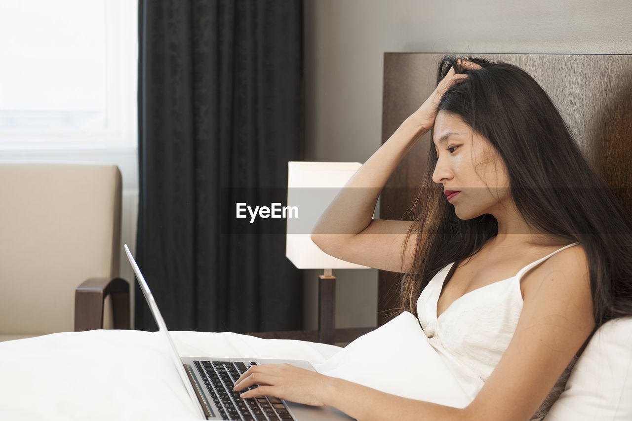 Beautiful woman checking her laptop in hotel room in iceland