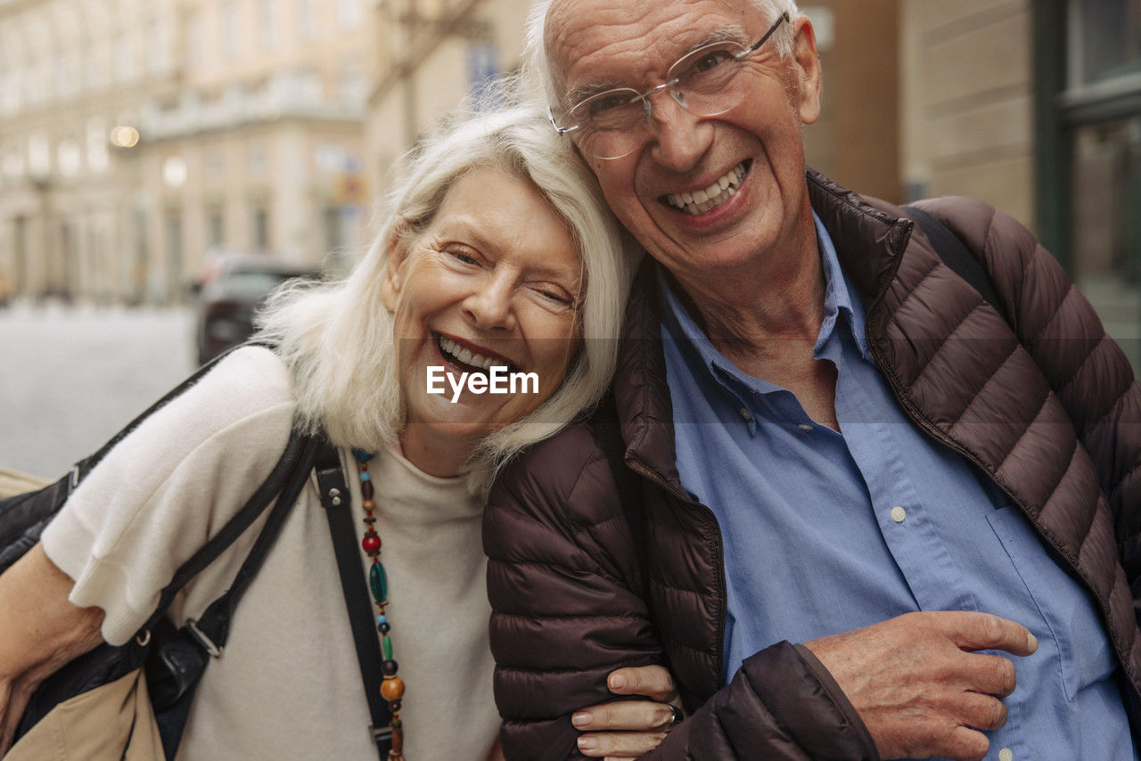 Portrait of happy senior couple in city