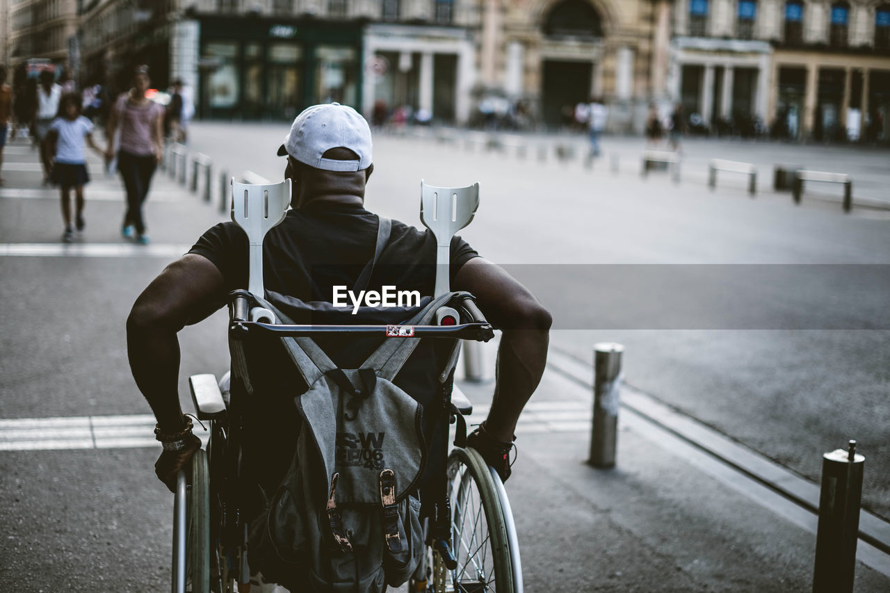 MAN RIDING BICYCLES ON STREET IN CITY