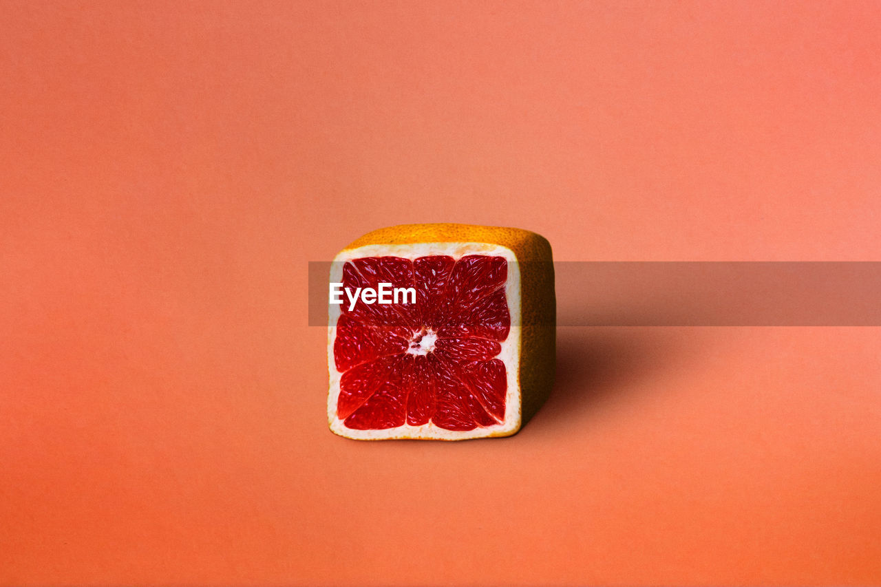 Close-up of grapefruit against orange background
