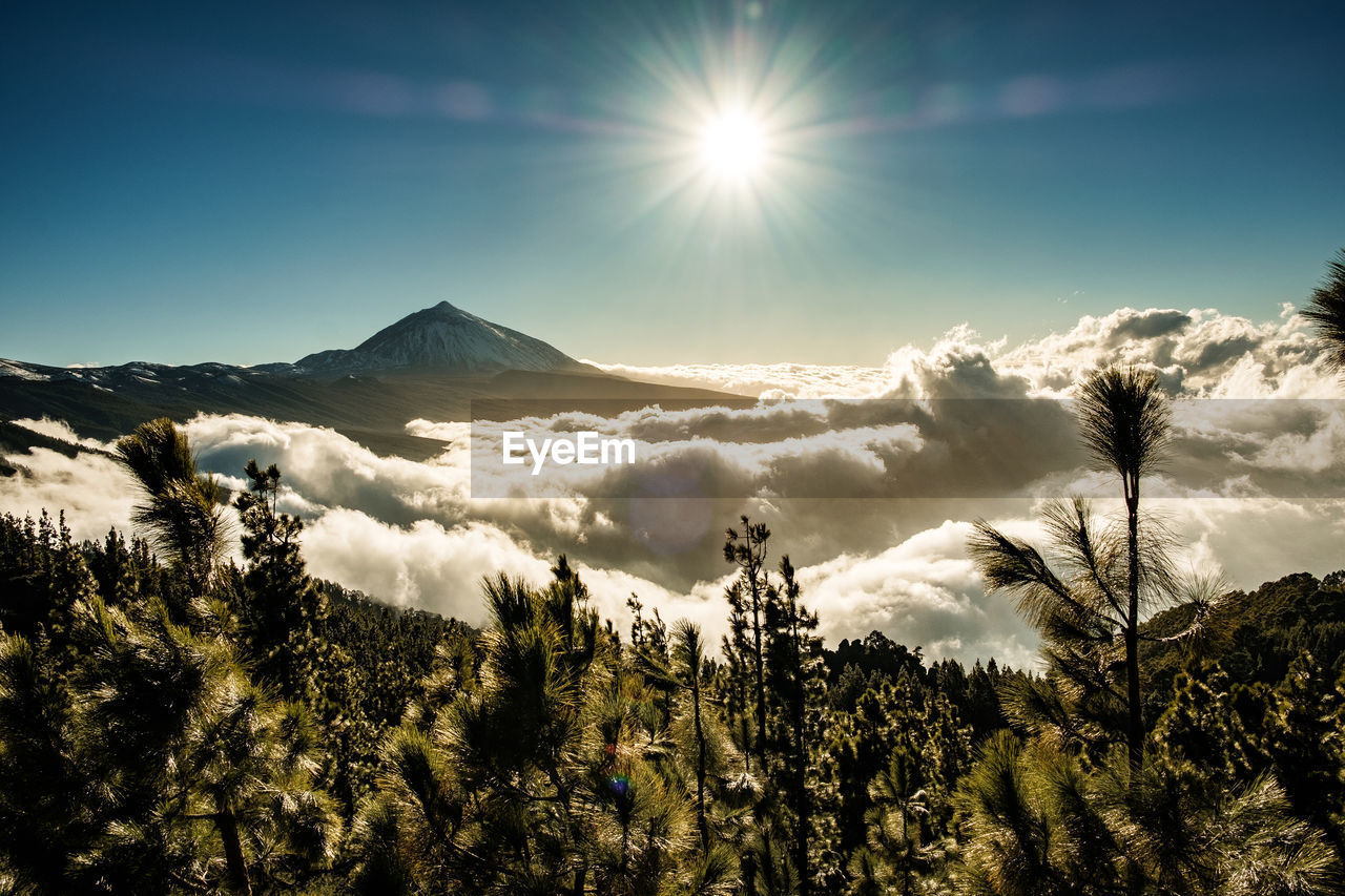 Scenic view of mountains against bright sun