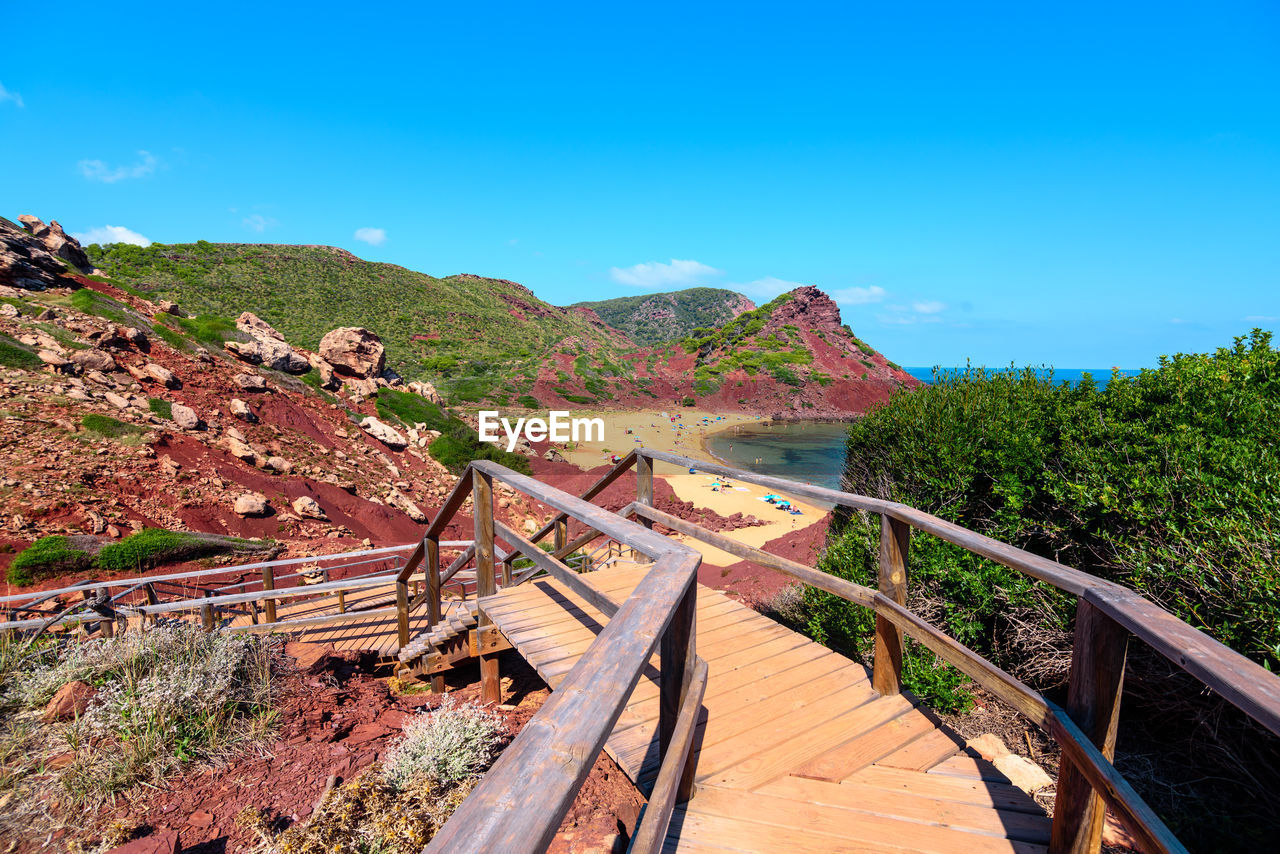 VIEW OF WOODEN FOOTBRIDGE AGAINST SKY