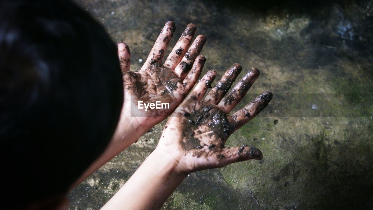 HIGH ANGLE VIEW OF MAN TOUCHING WATER ON LEAF