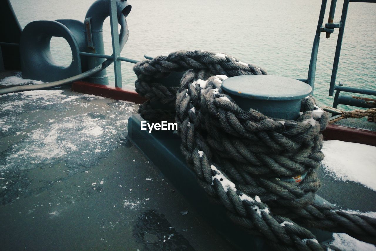 Close-up of rope tied to bollard on boat deck