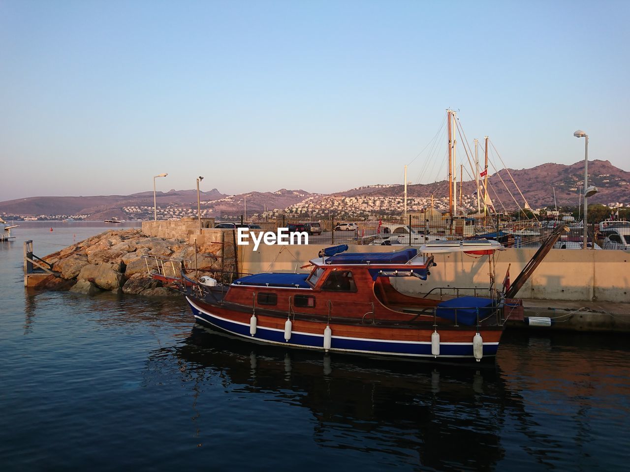 Boats moored at harbor against clear sky