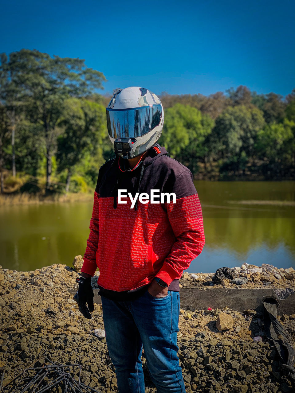 Rear view of man standing by lake