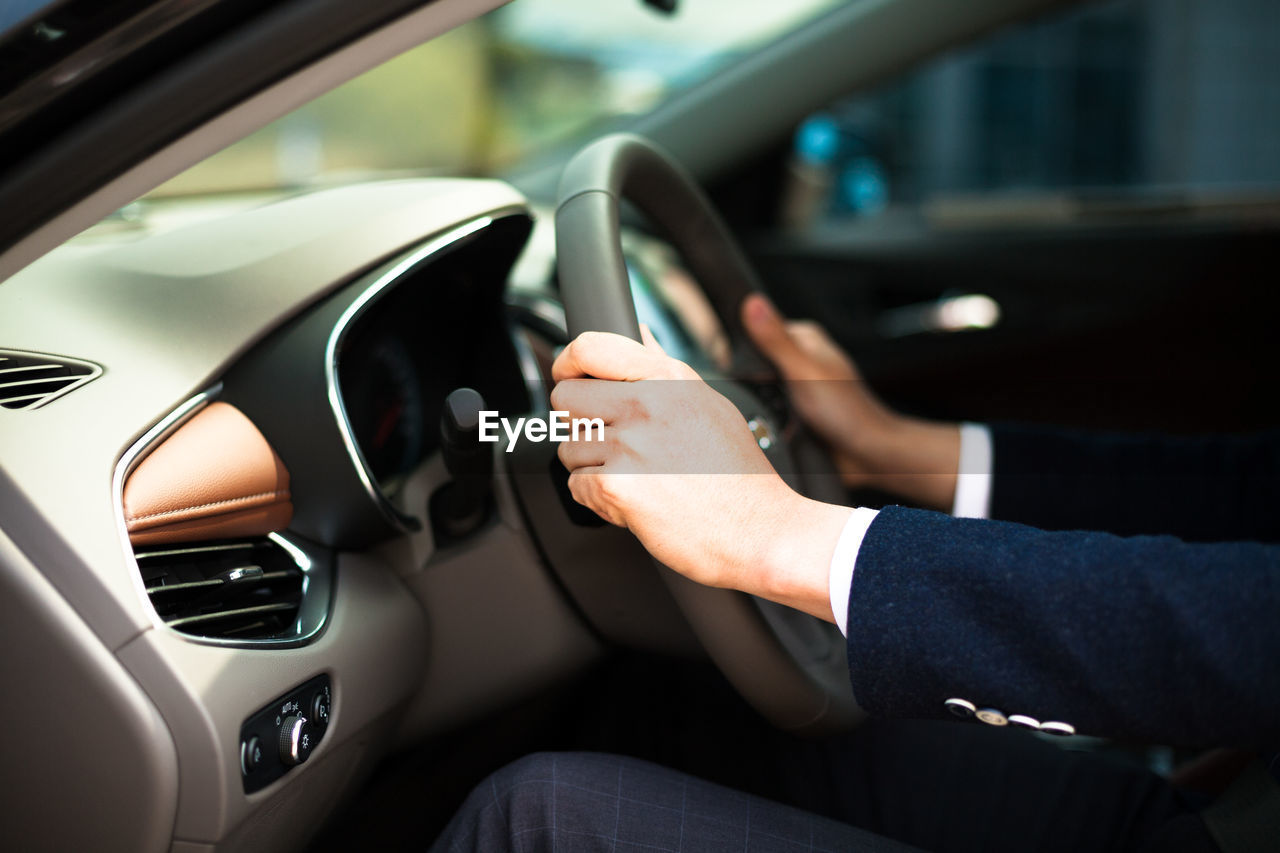 Cropped image of businessman driving car