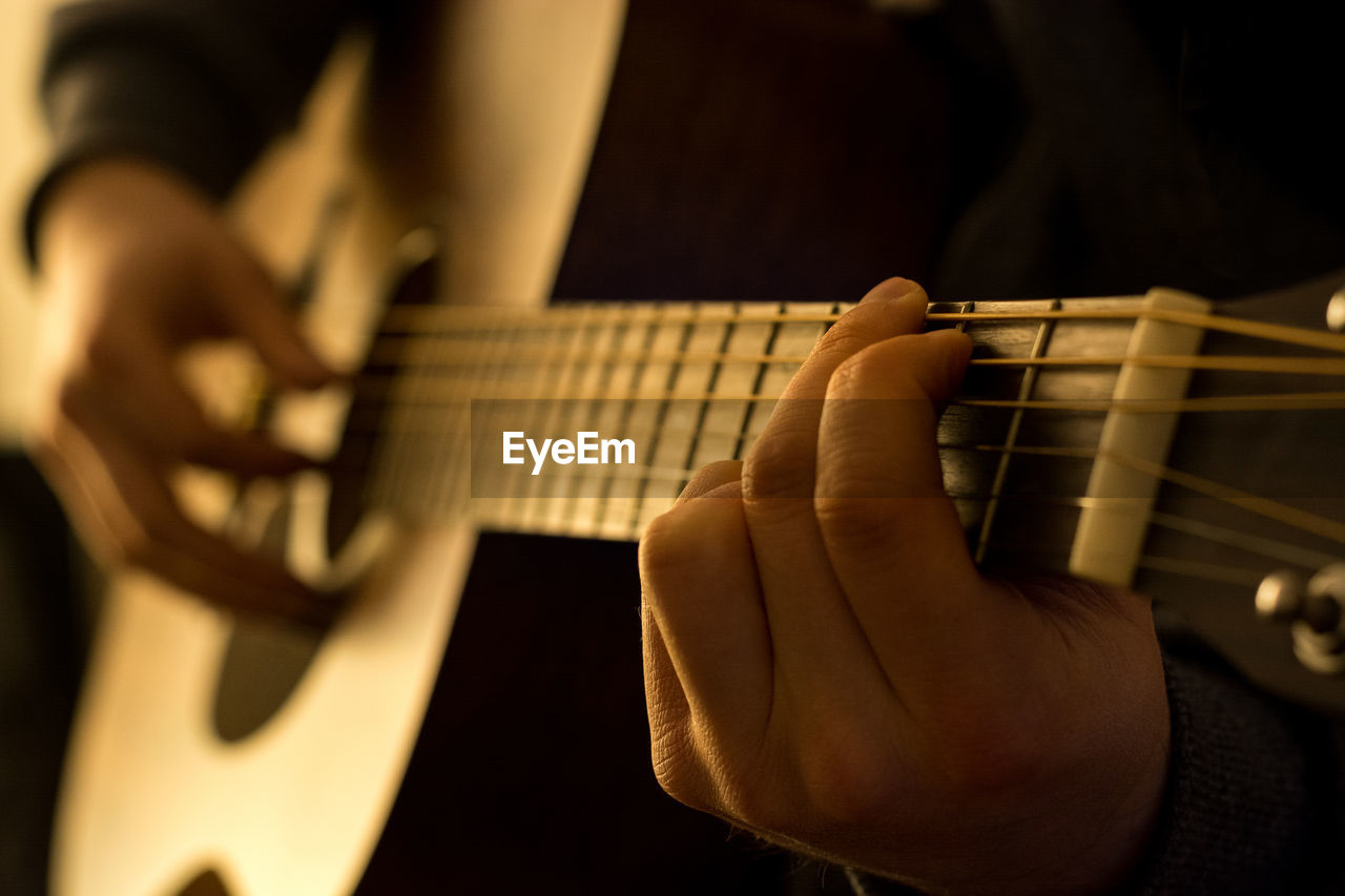 Cropped image of person playing guitar