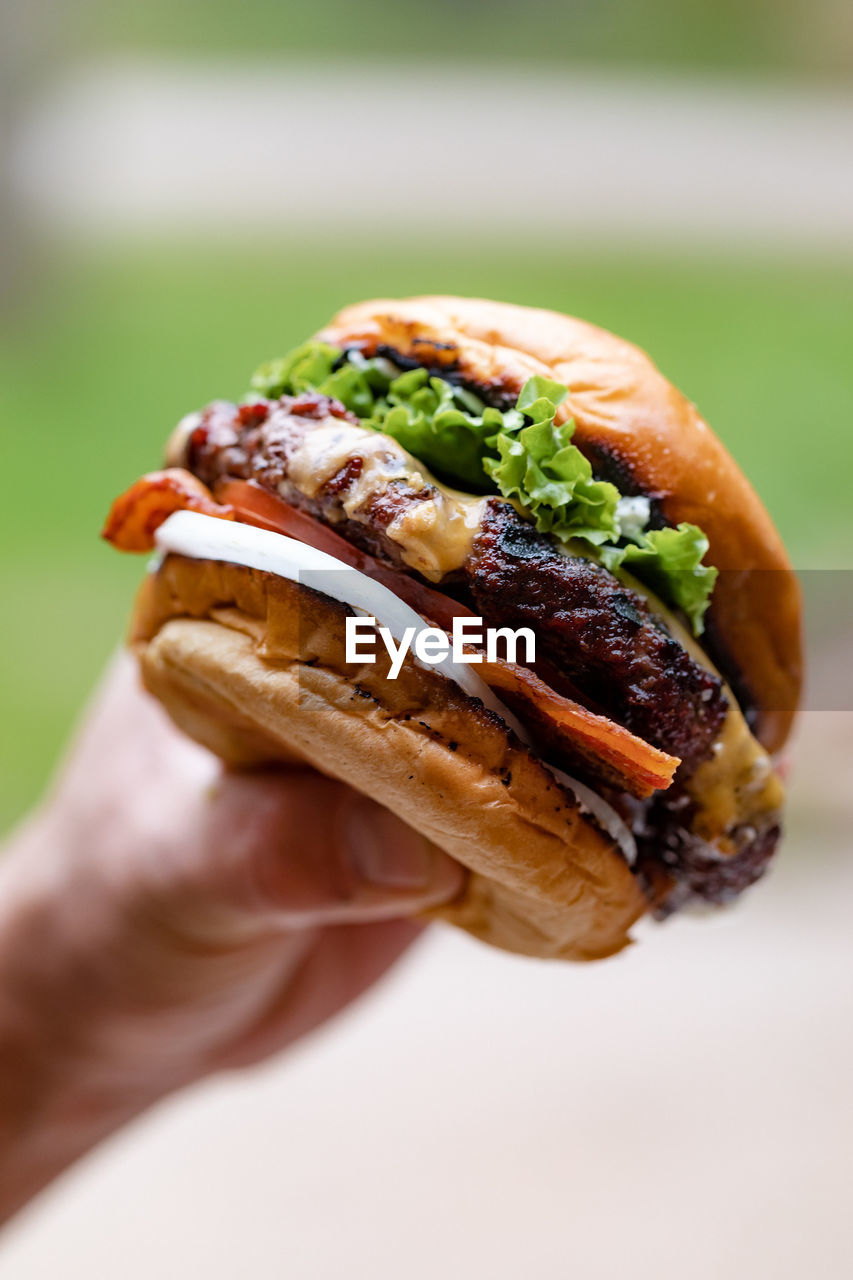 Close-up of hand holding a hamburger