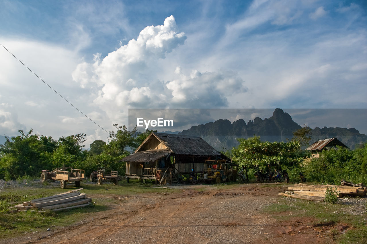 Hut on field with mountain against sky