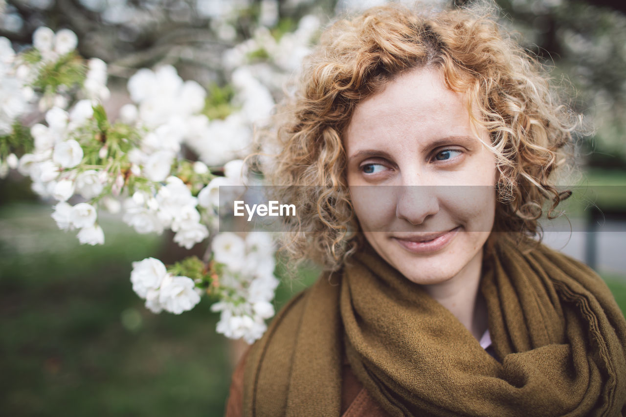 Woman looking away against blooming flowers