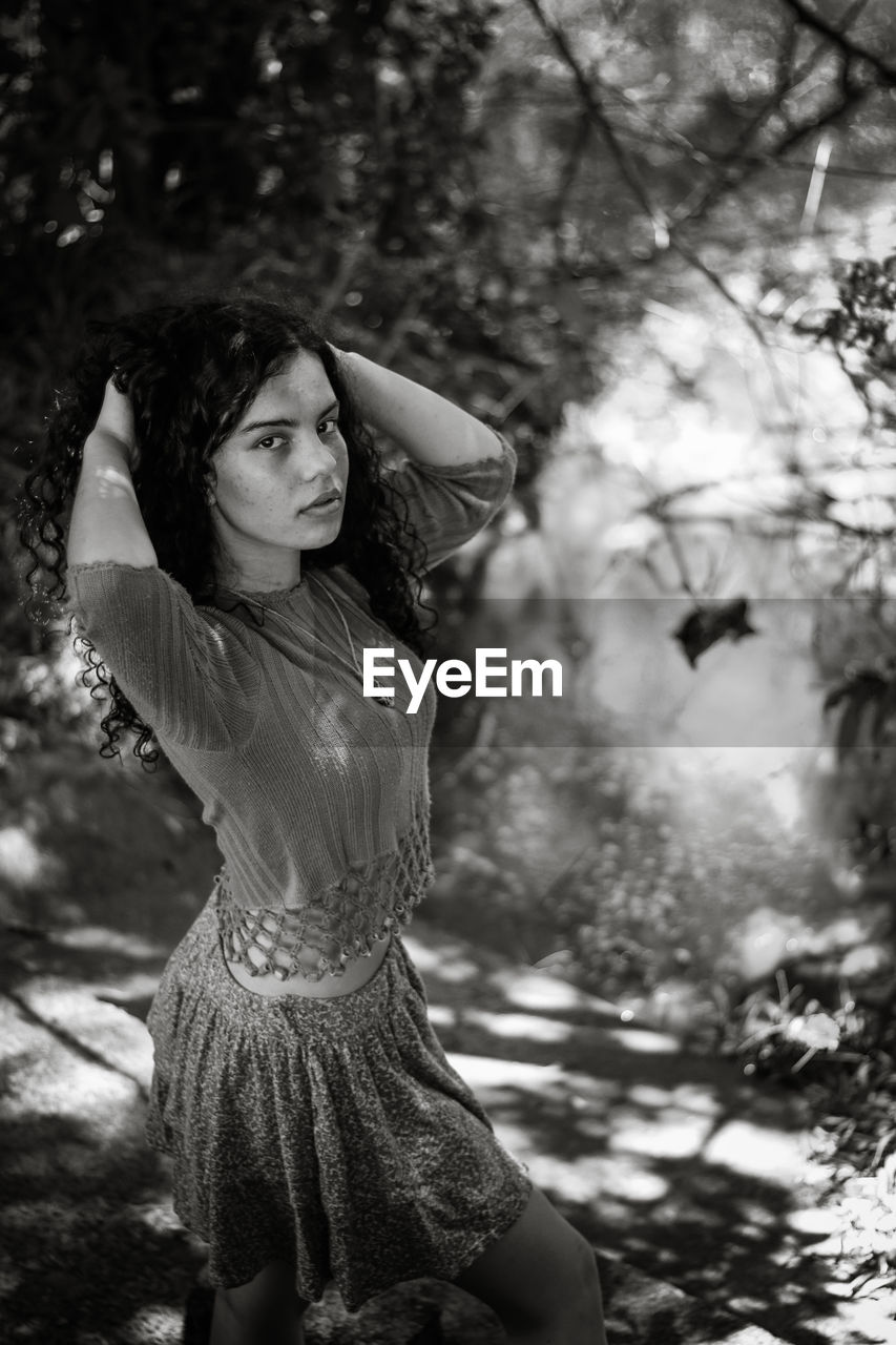 Young woman with tree against blurred background