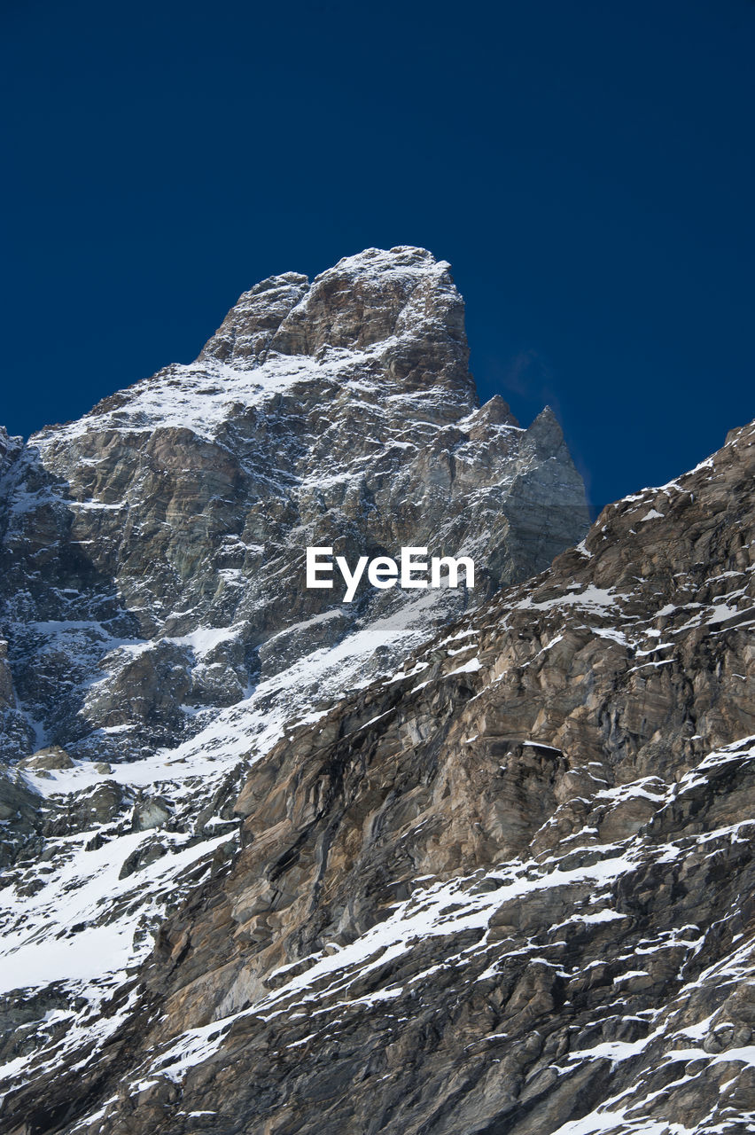 LOW ANGLE VIEW OF SNOWCAPPED MOUNTAIN AGAINST SKY