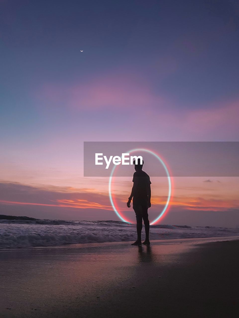 Digital composite image of man standing against circle on beach during sunset