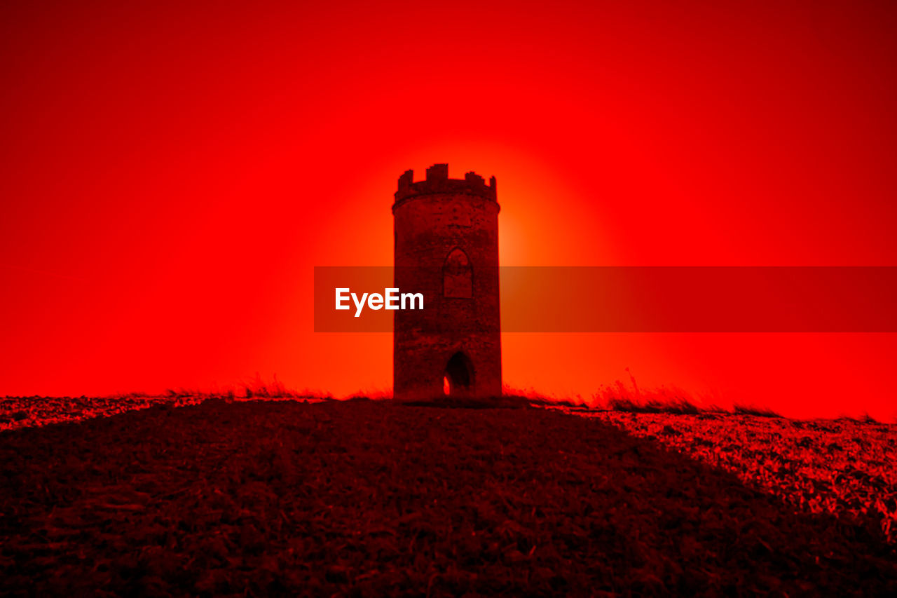 red, architecture, lighthouse, built structure, building exterior, history, tower, sunset, dawn, darkness, the past, nature, sky, night, no people, building, evening, land, travel destinations, horizon, beauty in nature, landscape, outdoors, ancient, fort, light