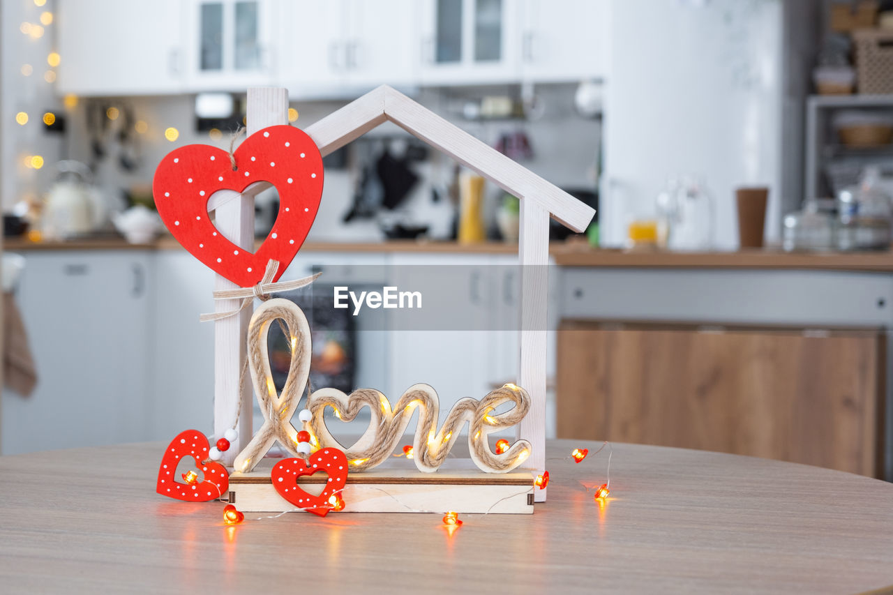 heart shape, indoors, no people, love, table, red, focus on foreground, positive emotion, emotion, home interior, decoration, candle, domestic room, celebration, wood, domestic life, home, day