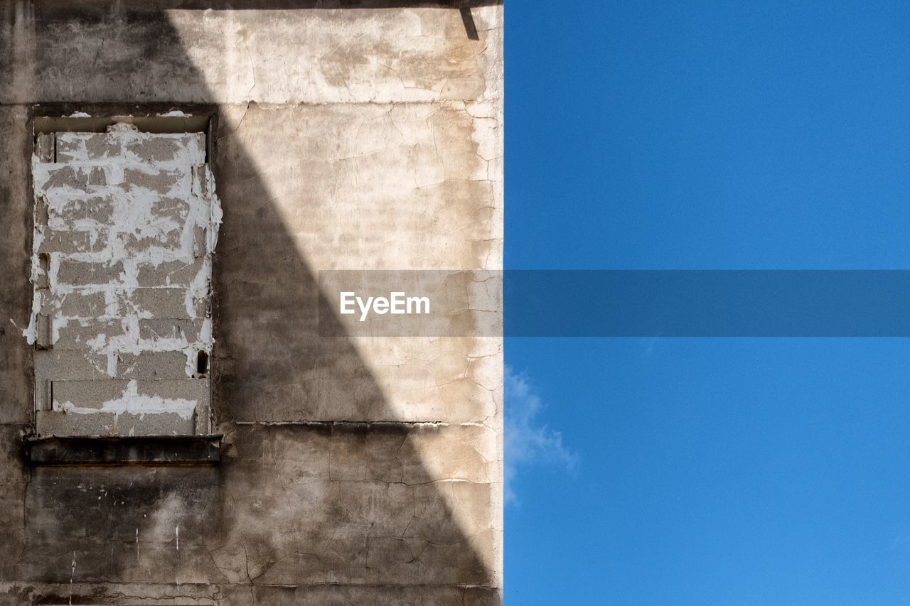 CLOSE-UP OF BUILT STRUCTURE AGAINST BLUE SKY