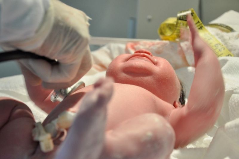 Newborn baby being checked by doctor