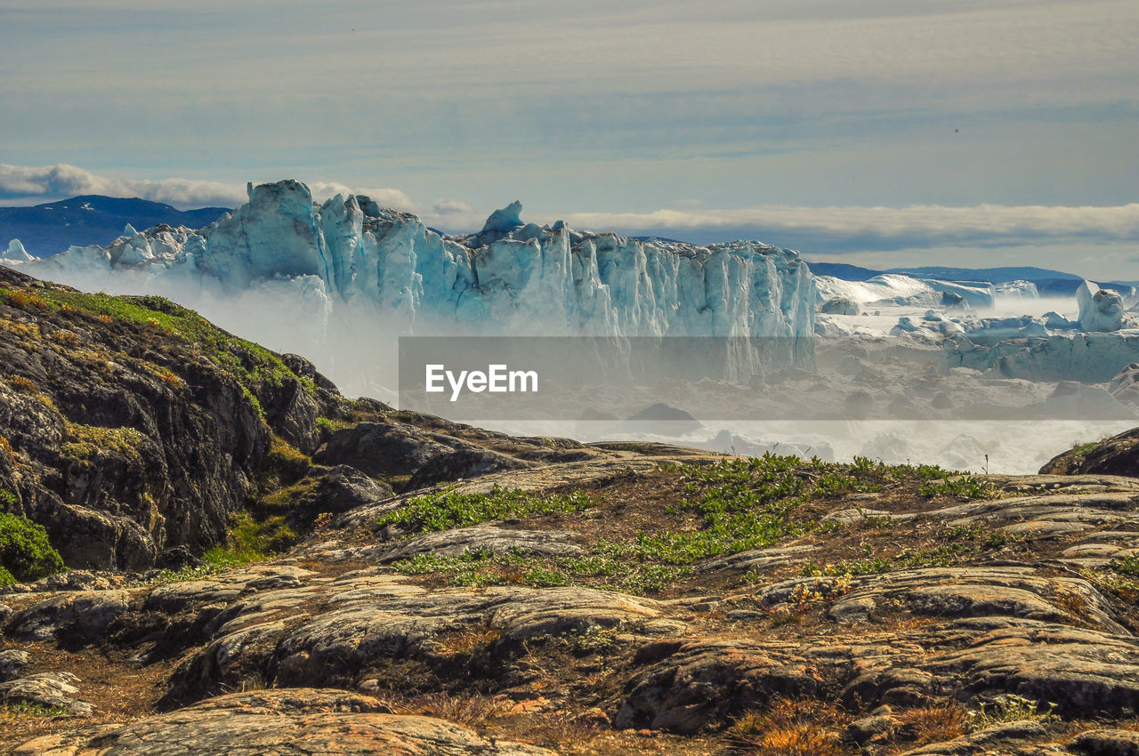 Scenic view of waterfall against sky