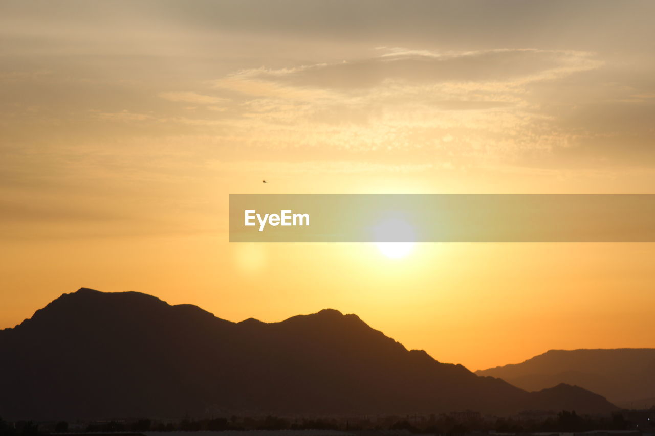 Silhouette mountains against sky during sunset